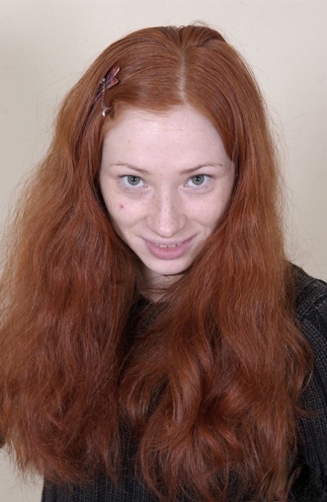 Redheaded American babe Millena exposes her slim body and presents her cunt