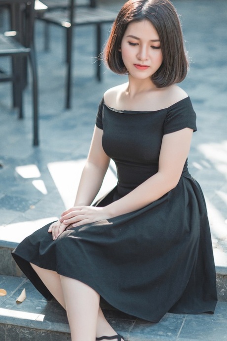 Glamorous Asian babe posing in her elegant black dress in public
