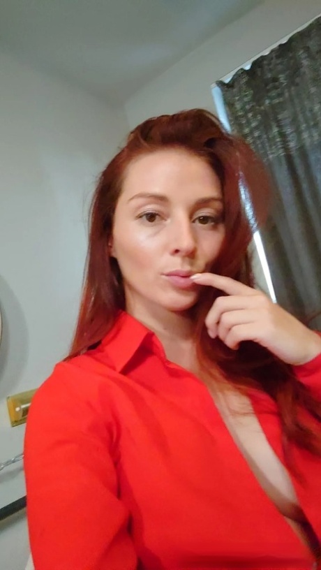 Gorgeous redhead shows off her big tits & her tattoos while taking nudes